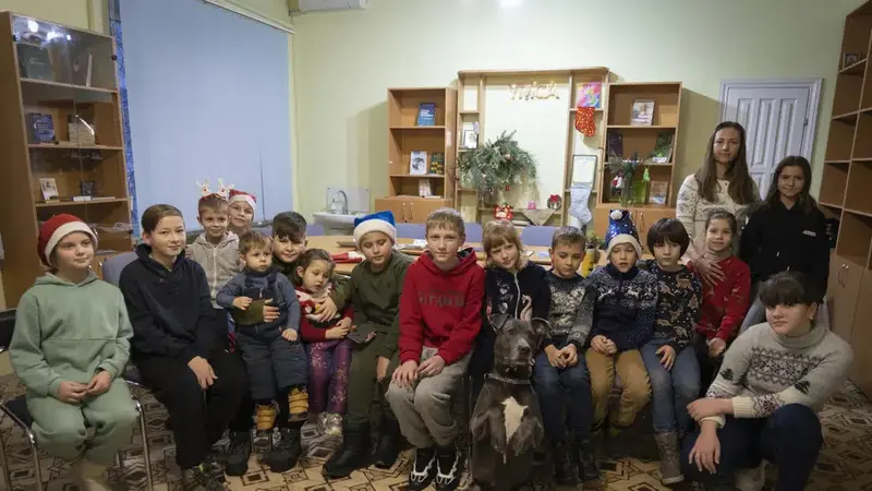 Anak-anak korban trauma perang Ukraina berfoto dengan American Pit Bull Terrier "Bice" di Pusat Rehabilitasi Sosial dan Psikologis di Boyarka, Ukraina, Rabu, 7 Desember 2022. (Vasilisa Stepanenko/AP Photo)