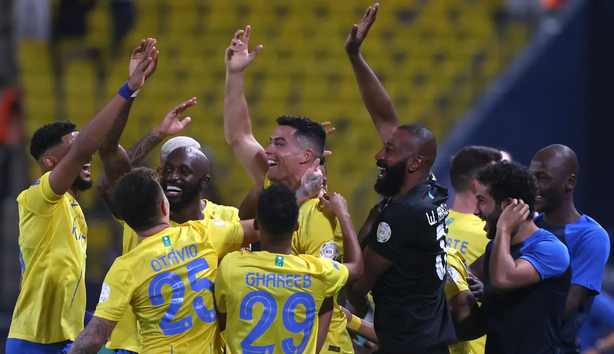 Selebrasi Striker Al Nassr, Cristiano Ronaldo (tengah) bersama rekan-rekannya setelah mencetak gol kedua timnya ke gawang Damac melalui tendangan bebas pada laga pekan ke-10 Liga Arab Saudi 2023/2024 yang berlangsung di King Saud University Stadium, Riyadh, Sabtu (21/10/2023) malam WIB. (AFP/Fayez Nureldine)