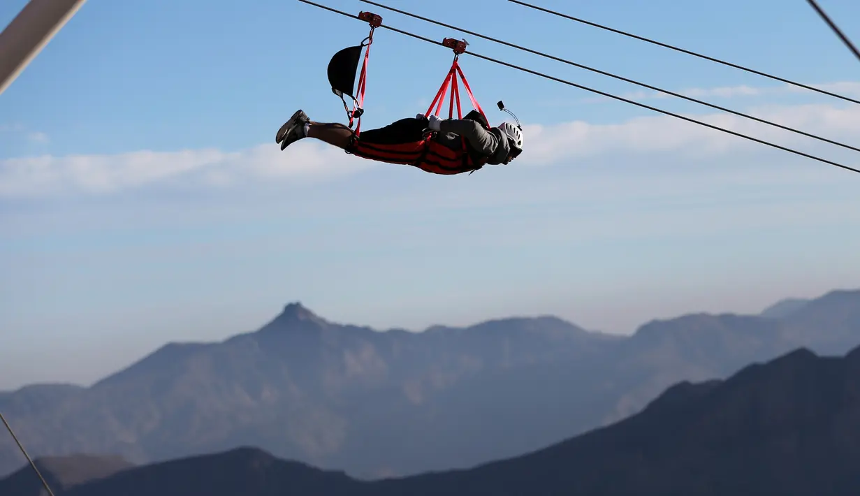 Wisatawan meluncur dengan flying fox dari atas Gunung Jabel Jais Ras al-Khamiah di Uni Emirat Arab, 31 Januari 2018. Flying fox yang diklaim terpanjang di dunia tersebut dirancang untuk mampu melayani 250 orang per harinya. (AP/Kamran Jebreili)