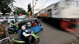 Sejumlah kendaraan berhenti di perlintasan kereta api Nomor 52 di Pisangan Lama, Jakarta, Kamis (11/4). Pintu perlintasan ini dan JPL 66 di Jalan Stasiun Cakung, Jaktim, akan ditutup permanen saat diberlakukannya Double Double Track (DDT) lintas Manggarai-Cikarang. (merdeka.com/Iqbal S. Nugroho)