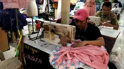 Seorang penjahit menjahit baju di Pasar Mayestik, Jakarta Selatan, Senin (11/6). Masyarakat mulai membeli dan membuat baju pilihan mereka jelang Lebaran. (Liputan6.com/JohanTallo)