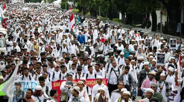 Massa demo 2 Desember mulai berjalan kaki menuju Monumen Nasional (Monas), Jakarta Pusat, Jumat (2/12). Dengan mengenakan pakaian serba putih, peserta demo 2 Desember sesekali mengucapkan kalimat takbir. (Liputan6.com/Faizal Fanani)