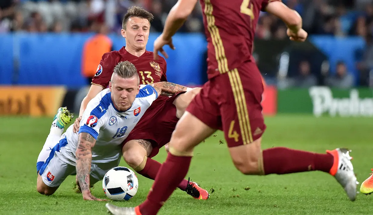 Pemain Slovakia, Juraj Kucka, dilanggar pemain Rusia, Aleksandr Golovin, pada laga kedua Grup B Piala Eropa 2016, Rabu (15/6/2016) malam WIB. (AFP/Philippe Huguen)