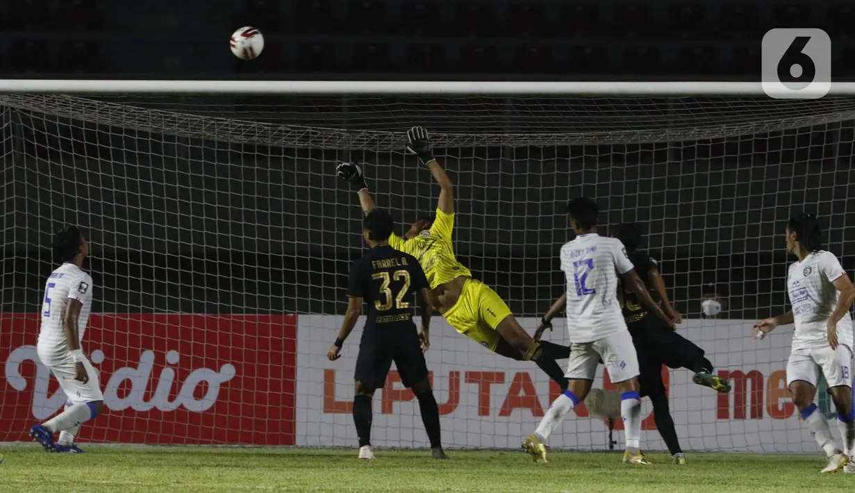 Kiper pemain Arema FC Utam Rusdiana berusaha menghalau bola tendangan dari pemain PSIS Semarang dalam pertandingan babak penyisihan Grup A Piala Menpora 2021 di Stadion Manahan, Solo, Selasa (30/3/2021). Arema FC kalah 2-3. (Bola.com/Ikhwan Yanuar)