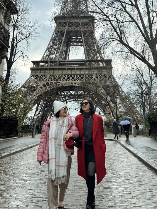 Ketika berkunjung ke menara Eiffel, keduanya tampil cerah dengan outfitnya. Febby mengenakan coat merah dipadukan halterneck dan mini skirt hitam.  [@febbyrastanty]
