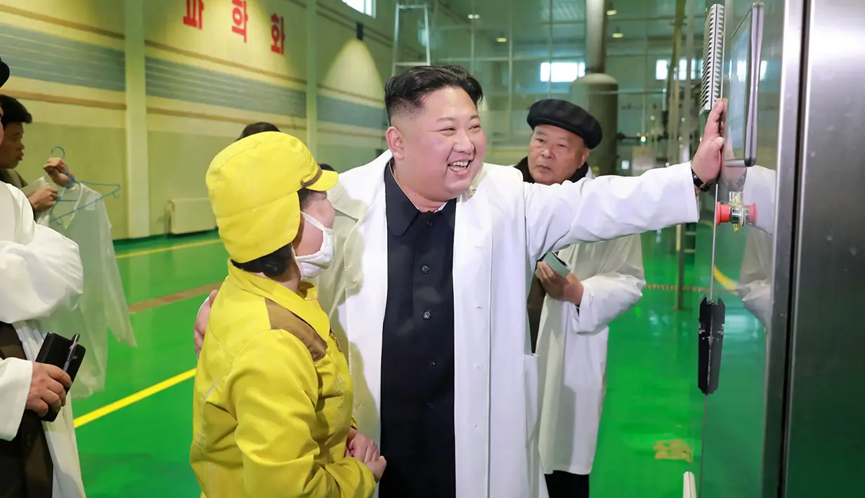 Pemimpin Korea Utara Kim Jong-un berbincang dengan salah satu pekerja di pabrik Samjiyon Potato Farina di Samjiyon, Kamis (4/4). Tahun lalu Kim Jong-un mengunjungi pabrik kentang saat kunjungan 19 harinya ke Samjiyon County di Provinsi Ryanggang yang berbatasan dengan China. (AFP Photo/KCNA VIA KNS)