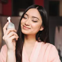ilustrasi perempuan sedang memegang parfum/ copyright freepik.com/lookstudio