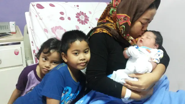 Fitrianti Anggraini mencium anak ketiganya yang berbobot 5,1 Kilogram (Liputan6.com/Nefri Inge)