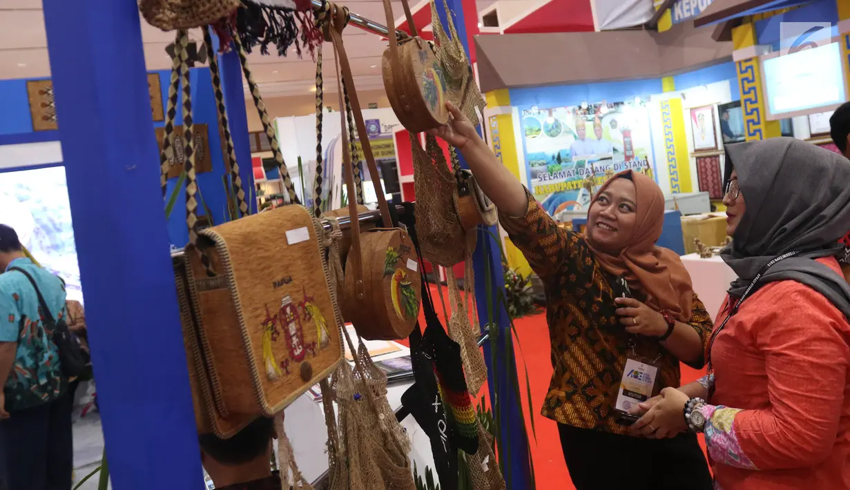 Pengunjung melihat produk kerajinan yang dipamerkan dalam Apkasi Otonomi Expo (AOE) di JCC Jakarta, Rabu (3/7/2019). Selain pameran, AOE 2019 juga menghadirkan forum bisnis, workshop, field trip, pertunjukan seni budaya daerah hingga zona kuliner Nusantara. (Liputan6.com/Angga Yuniar)