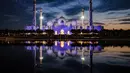 Masjid Agung Sheikh Zayed menyala saat matahari terbenam di Abu Dhabi selama Laylat al-Qadr, salah satu malam paling suci selama bulan puasa Ramadhan pada 17 April 2023. (Photo by Karim SAHIB / AFP)