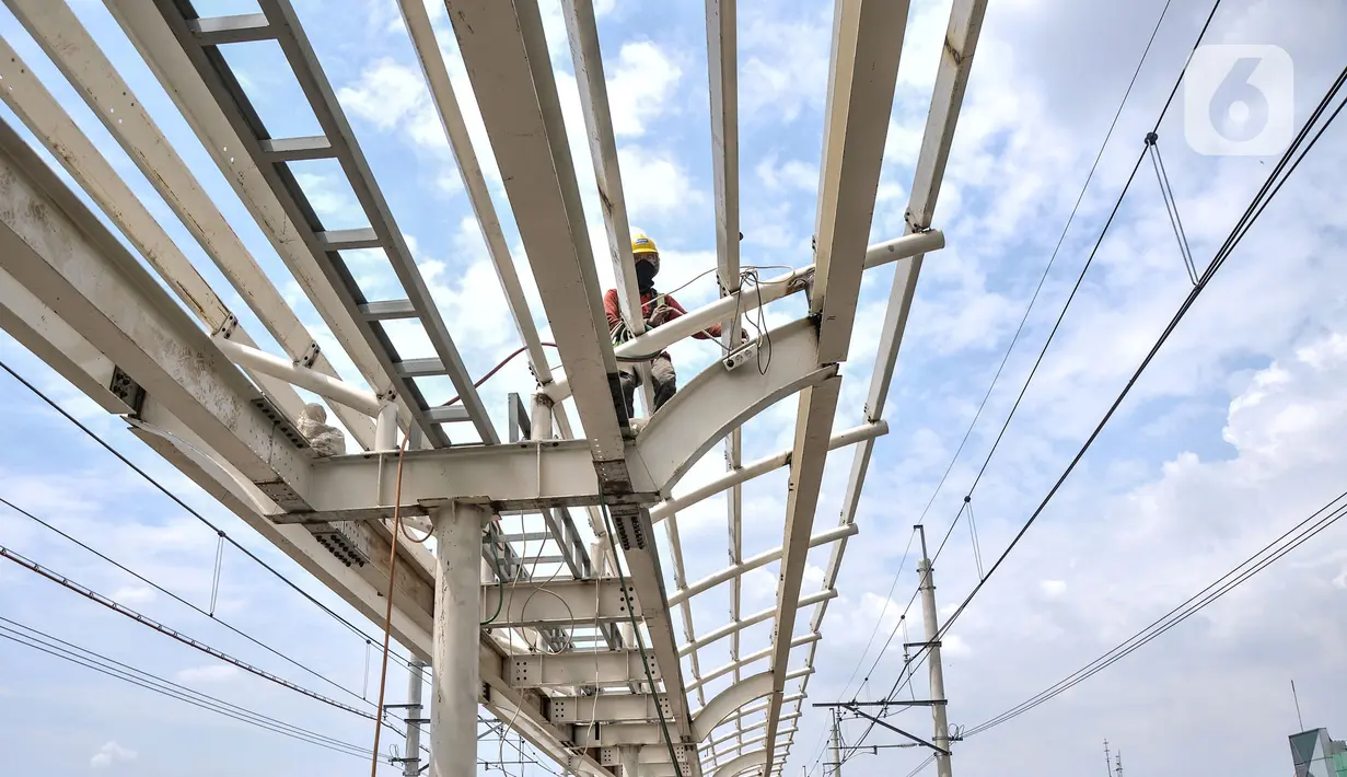 Pekerja menyelesaikan pemasangan atap peron Stasiun Matraman, Jakarta Timur, Kamis (23/12/2021). Balai Teknik Perkeretaapian Wilayah Jakarta Banten (BTPWJB) terus mengebut pembangunan Stasiun Matraman yang ditargetkan dapat beroperasi pada 2022 mendatang. (merdeka.com/Iqbal S. Nugroho)
