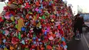Sepasang pengunjung mengamati gembok cinta yang menutupi pagar di Namsan Seoul Tower, Korea Selatan, Selasa (29/1). Mitosnya, pasangan yang mengaitkan gembok cinta dan membuang kuncinya ke bawah akan menjadi pasangan abadi. (AP/Ahn Young-joon)