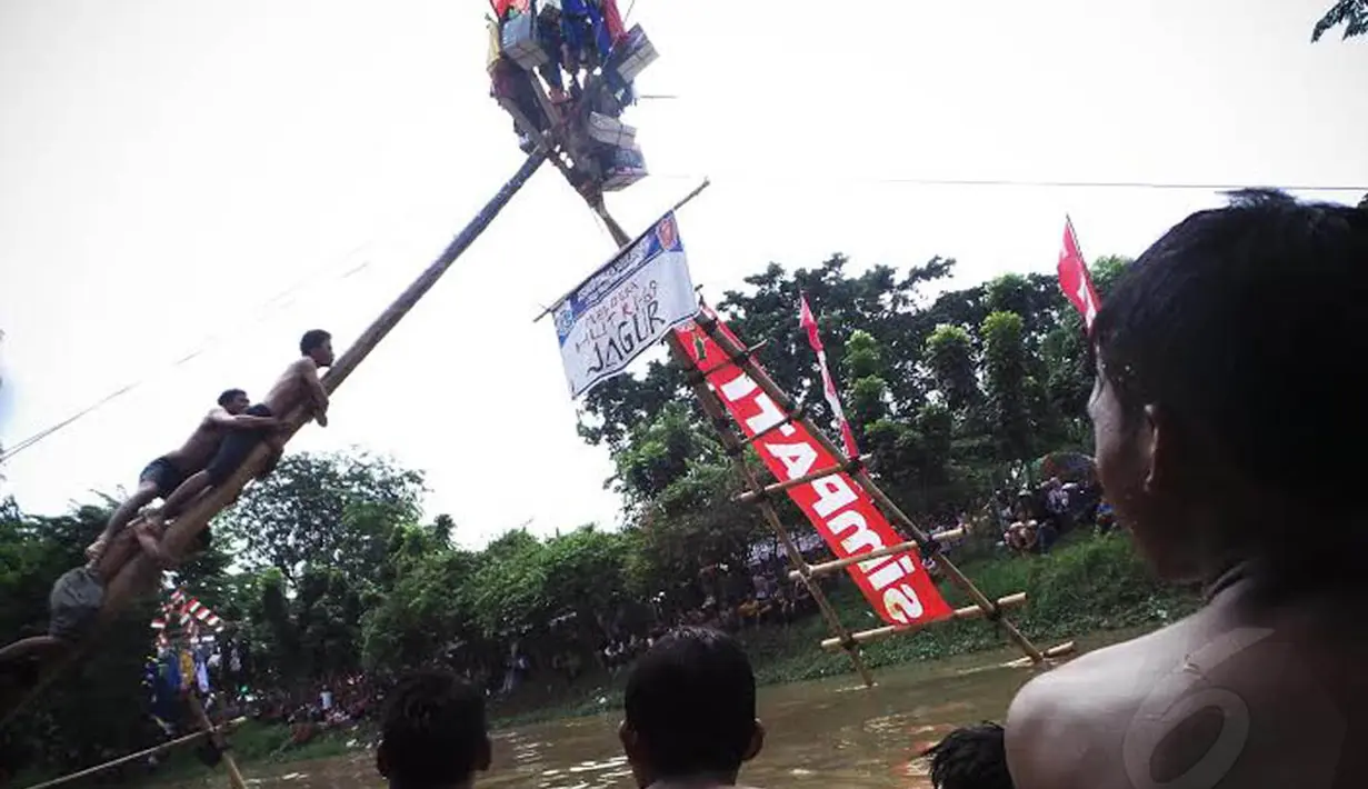  Tampak sejumlah peserta bahu membahu menggapai hadiah yang ada di puncak pohon pinang (Liputan6.com/Faizal Fanani)