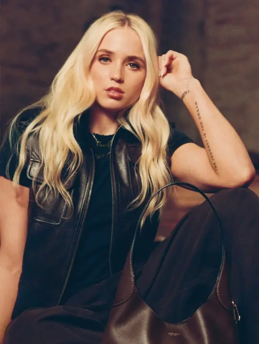 Hailey Van Lith dari Chicago Sky tampil dengan vest leather hitam senada dengan warna hitam dan celana hitamnya. Ia tampil dengan tas Coach tote bag warna coklat. [Coach]