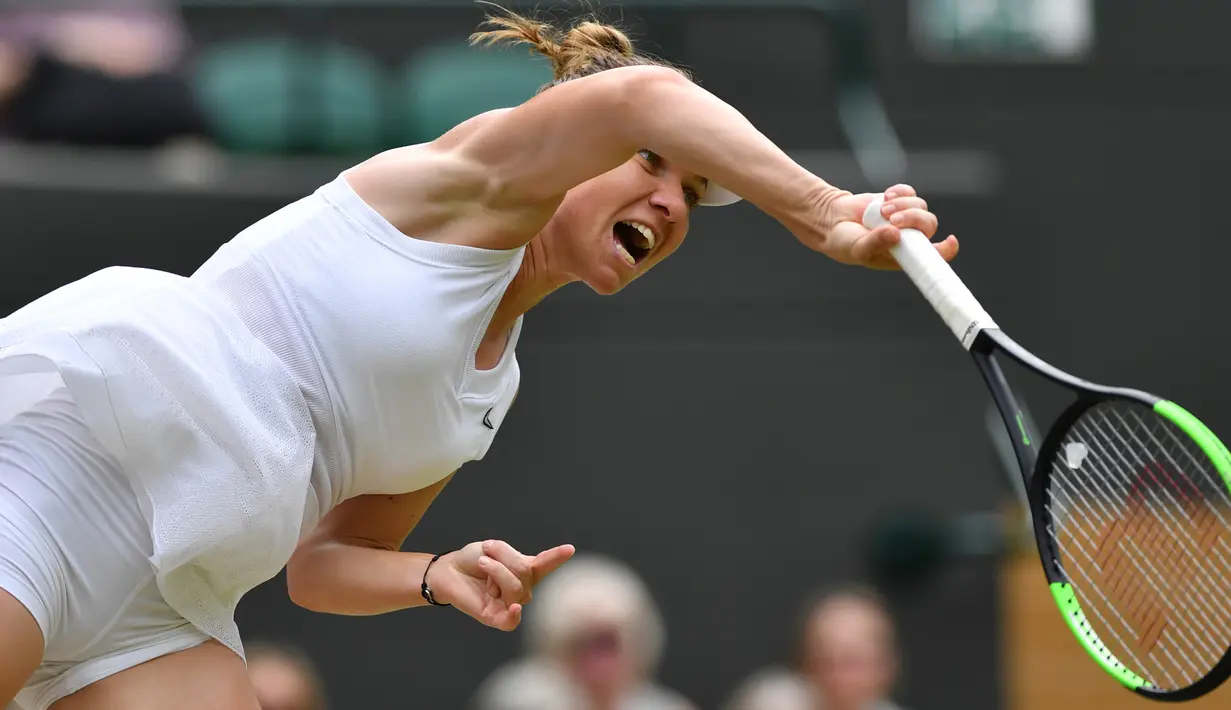 Petenis Rumania, Simona Halep melakukan servis ke arah petenis China, Shuai Zhang pada perempat final Grand Slam Wimbledon di London, Selasa (9/7/2019). Untuk kali pertama dalam lima musim terakhir, unggulan ketujuh Simona Halep akan melakoni babak empat besar di Wimbledon. (GLYN KIRK / AFP)