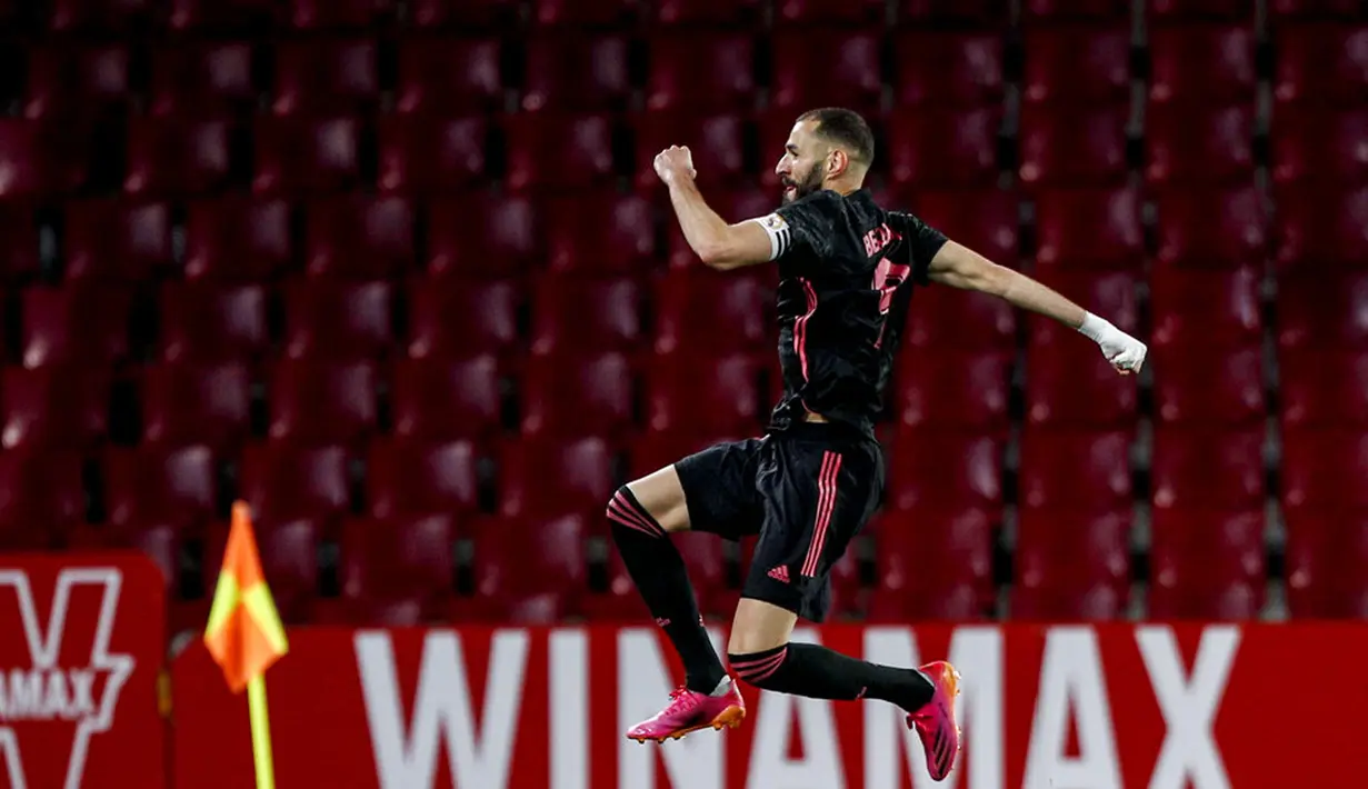 Pemain Real Madrid Karim Benzema melakukan selebrasi usai mencetak gol ke gawang Granada pada pertandingan La Liga di Stadion Los Carmenes, Granada, Spanyol, Kamis (13/5/2021). Real Madrid menang telak 4-1 atas Granada. (AP Photo/Fermin Rodriguez)