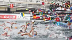 Perenang meraih botol minuman saat berlaga dalam lomba renang air terbuka nomor 10 km putra di Kejuaraan Renang Dunia di Yeosu, Korea Selatan, Selasa (16/7/2019). (HANDOUT/FINA ORGANISING COMMITTEE VIA YONHAP/AFP)