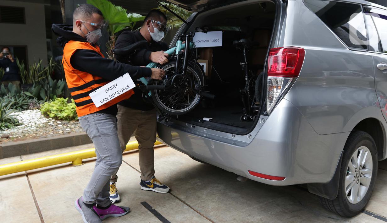 Tersangka Harry Sidabuke (kiri) bersama perantara anggota Komisi II DPR Ihsan Yunus, Agustri Yogasmara memasukkan sepeda ke dalam mobil saat rekonstruksi perkara dugaan korupsi pengadaan bantuan sosial penanganan COVID-19 di gedung KPK, Jakarta, Rabu (10/2/2021). (Liputan6.com/Helmi Fithriansyah)