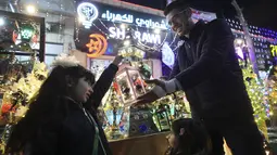 Seorang pedagang Palestina memajang lentera tradisional "fanous" di Hebron di Tepi Barat yang diduduki pada 27 Maret 2022. Fanous merupakan lentera untuk dekorasi yang digunakan merayakan awal bulan suci Ramadan. (HAZEM BADER / AFP)