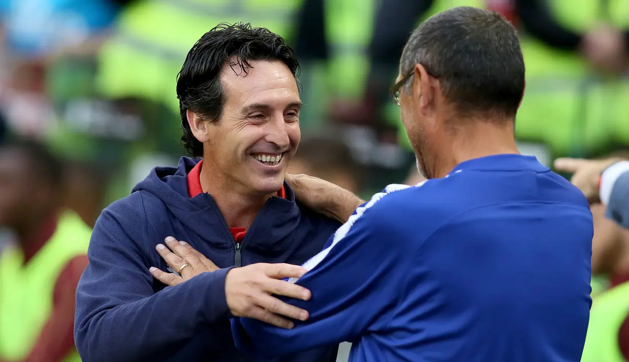 Pelatih Arsenal Unai Emery (kiri) dan Pelatih Chelsea Maurizio Sarri saling menyapa sebelum pertandingan International Champions Cup (ICC) di Stadion Aviva di Dublin (1/8). Arsenal menang atas Chelsea lewat adu penalti 6-5. (AFP Photo/Paul Faith)