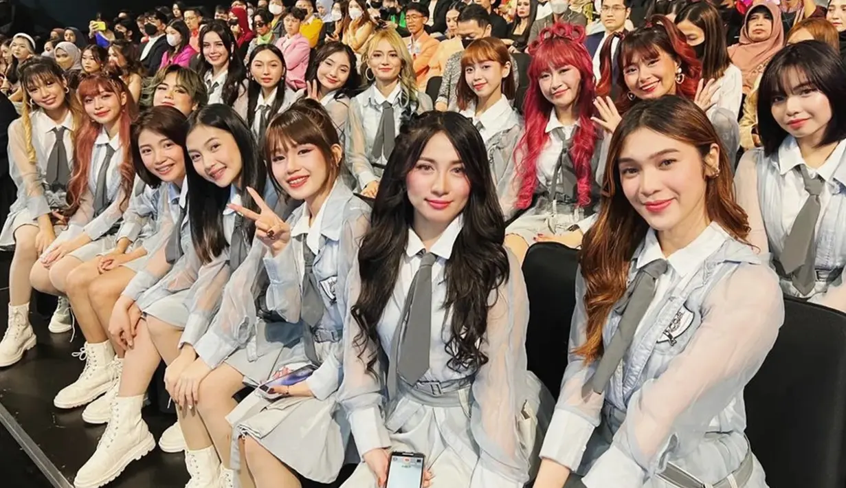 Para gadis MNL48 tampil memesona dalam balutan outfit berwarna abu-abu dan sepatu putih. Semua kompak menebar senyum ke arah kamera yang mengabadikan momen mereka. Datang ber-16, mereka tampak begitu mencolok dengan visual masing-masing saat ikut duduk di bangku penonton. (Liputan6.com/IG/@mnl48official)