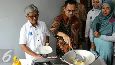 Menteri ESDM Sudirman Said mencoba memasak telur dengan menggunakan gas bumi, Bekasi, Kamis (3/3/2016). Aksi memasak ini dilakukan di rumah seorang warga yang sudah dialiri gas bumi. (Liputan6.com/Yoppy Renato)