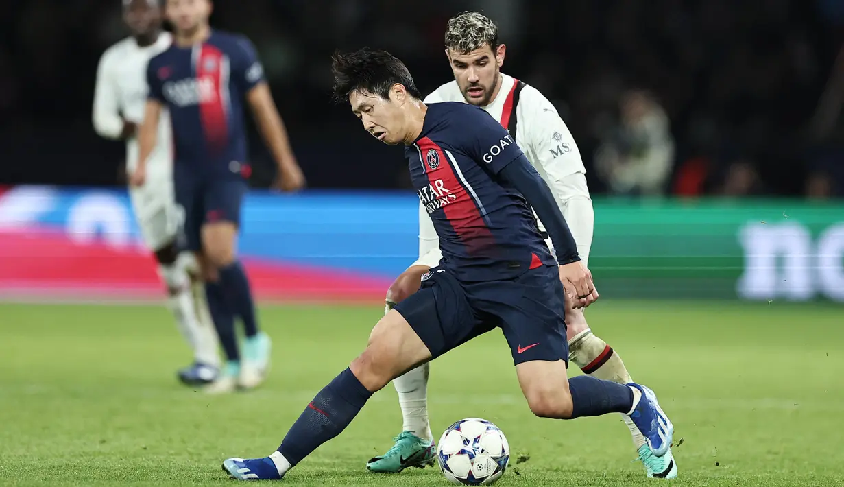 Pemain Paris Saint-Germain (PSG), Lee Kang-in, berusaha mengecoh pemain AC Milan, Theo Hernandez, pada laga Liga Champions di Stadion Parc de Princes, Paris, Kamis (26/10/2023). (AFP/Franck Fife)
