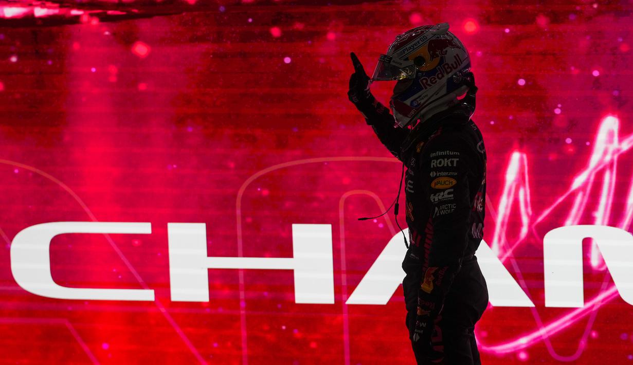 Pembalap Red Bull Racing, Max Verstappen merayakan keberhasilannya menjadi juara dunia F1 2023 setelah menjadi pemenang pada sesi Sprint Race Grand Prix (GP) Qatar, Minggu (8/10/2023) dini hari. (AP Photo/Darko Bandic, Pool)