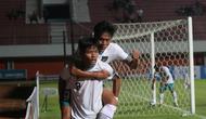 Penyerang Timnas Indonesia U-16, Arkhan Kaka, menggendong rekan setimnya, Muhammad Kafiatur Rizky, setelah ia memberikan assist untuk gol yang dicetak Kafiatur dalam laga melawan Singapura di Piala AFF U-16 2022, Rabu (3/8/2022). (Bola.com/Hery Kurniawan)