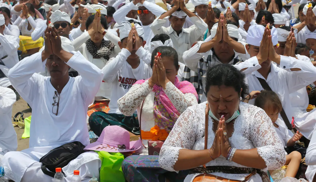 Umat Hindu memanjatkan doa saat menggelar ritual Melasti di Bali, Senin (4/3). Tradisi yang ada sejak Kerajaan Hindu Majapahit ini merupakan rangkaian dari perayaan Hari Raya Nyepi. (AP Photo/Firdia Lisnawati)