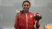 Atlet Lompat Jauh Indonesia, Maria Natalia Londa, berhasil menambah pundi emas tim Indonesia di Asian Games 2014. Maria Natalia Londa berpose dengan medalinya di podium kemenangan, (29/9/2014). (AFP PHOTO/Manan Vatsyayana)