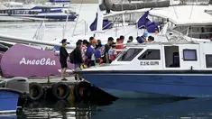 Turis Tiongkok menaiki kapal cepat untuk perjalanan dari Pulau Serangan ke Pulau Lombok di Denpasar, Bali, Rabu (25/1/2023). Aktivitas pariwisata khususnya dari China di Kelurahan Serangan, Denpasar Selatan semakin ramai. (AFP/Sonny Tumbelaka)