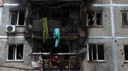 Serangan pesawat tak berawak Rusia menyebabkan kebakaran dan menghanguskan salah satu ruang di gedung apartemen yang terdampak. (Anatolii STEPANOV/AFP)