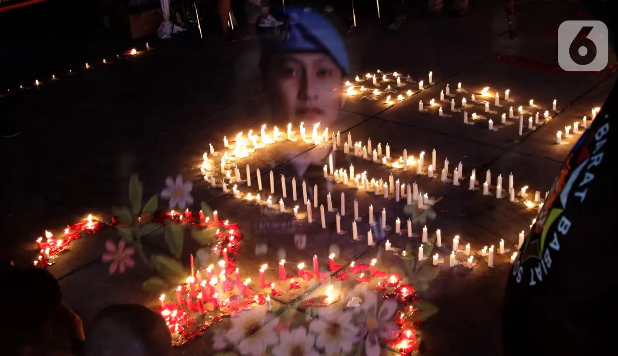Foto multiple exposure menggambarkan nyala lilin dan spanduk bergambar Brigadir Novriansyah Joshua Hutabarat alias Brigadir J di kawasan Taman Ismail Marzuki (TIM), Jakarta, Senin (8/8/2022). Aksi tersebut bertajuk “Keadilan untuk Joshua! Aksi menyalakan 3000 lilin dan doa bersama mengenang kematian Brigadir J”. (Liputan6.com/Helmi Fithriansyah)