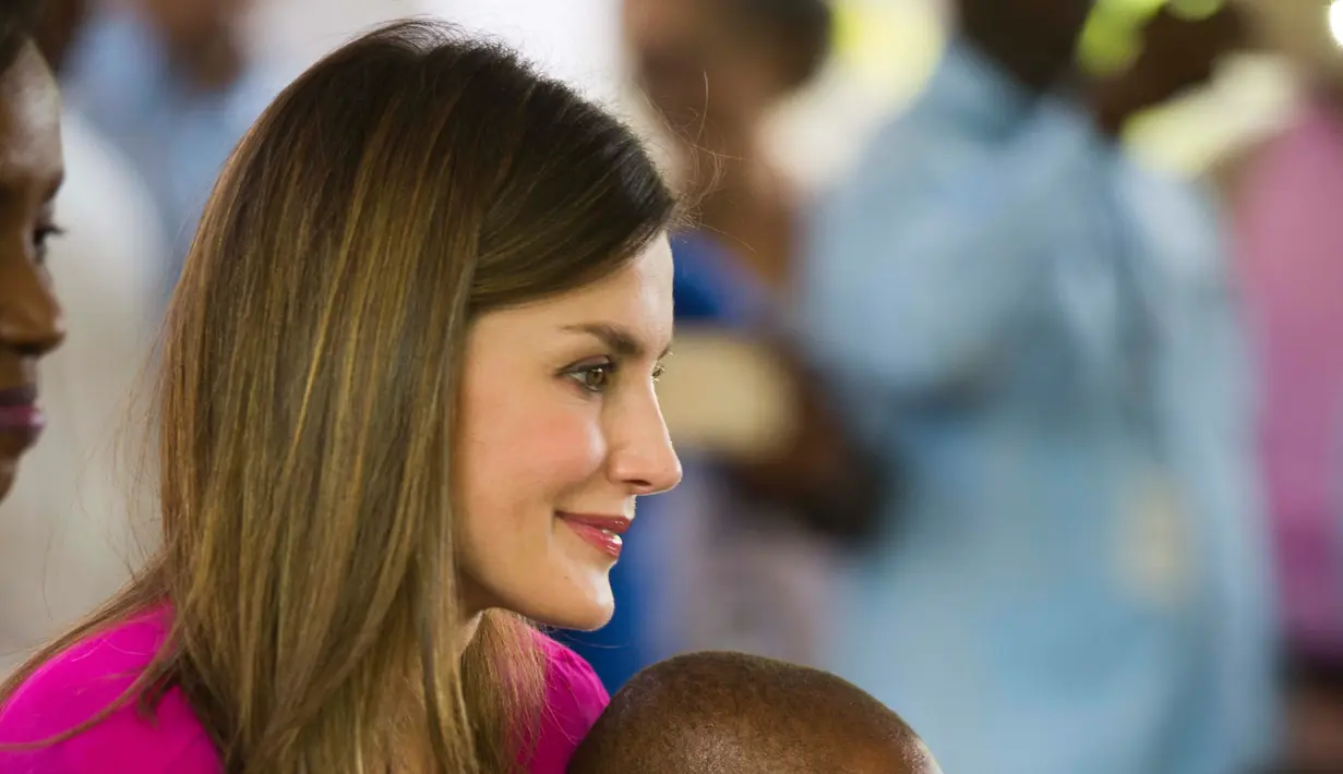 Ratu Spanyol Letizia memangku seorang anak saat upacara penyambutannya di sebuah sekolah daerah kumuh Soleil, Haiti, 23 Mei 2018. Ini merupakan kunjungan pertama Ratu Letizia ke negara termiskin di benua Amerika tersebut. (AP/Dieu Nalio Chery)