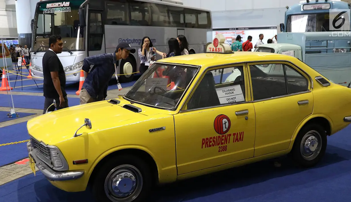 Pengunjung mengamati taksi yang dipajang dalam pameran Indonesia Classic N Unique Bus 2019 di JIExpo Kemayoran, Jakarta, Rabu (20/3). Pameran ini berlangsung pada 20-22 Maret 2019. (Liputan6.com/Immanuel Antonius)