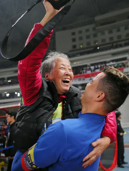 Kapten dan pemain internasional Kolombia Giovanni Moreno mengangkat fotografer Hong Nanli setelah pertandingan sepak bola FA China antara Shanghai Shenhua dan SIPG di Shanghai pada 26 November 2017 .(AFP Photo/China Out)