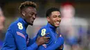 Striker Inggris Tammy Abraham (kiri) dan gelandang Inggris Jude Bellingham (kanan) tertawa bersama selama sesi latihan tim di stadion St George's Park di Burton-upon-Trent, Senin (30/5/2022). Timnas Inggris akan menjalani laga perdana Grup 3 League A UEFA Nations League dengan menghadapi Hungaria di Budapest pada Sabtu WIB, 4 Juni 2022. (Paul ELLIS/AFP)