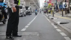 Petugas satlantas mensterilkan jalur sepeda di kawasan Blok A, Jakarta, Senin (25/11/2019). Mulai hari ini, polisi akan menilang para pengendara kendaraan bermotor yang nekat masuk dan melintas di jalur sepeda. (Liputan6.com/Faizal Fanani)
