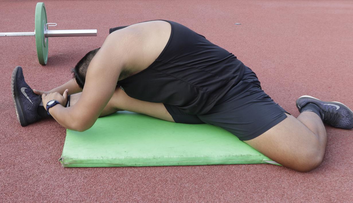 Atlet lontar martil, Rafika Putra, melakukan pemanasan saat latihan jelang SEA Games 2019 di Stadion Madya, Jakarta, Rabu (9/9). Pria berusia 20 tahun ini menargetkan medali emas pada debutnya di SEA Games. (Bola.com/M Iqbal Ichsan)