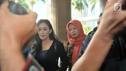Terpidana kasus pelanggaran ITE Baiq Nuril Maknun (kanan) didampingi politikus PDIP Rieke Diah Pitaloka tiba di Kantor Kemenkumham, Jakarta, Senin (8/7/2019). Guru honorer itu divonis 6 bulan penjara dan denda Rp 500 juta atas perekaman pelecehan seksual yang dialaminya. (merdeka.com/Iqbal Nugroho)