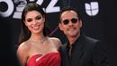 Marc Anthony bersama tunangannya model Paraguay Nadia Ferreira berpose saat tiba menghadiri penghargaan Grammy Latin ke-23 di Michelob Ultra Arena Mandalay Bay di Las Vegas, Nevada, pada 17 November 2022. Pelantun Vivir Mi Vida menyisir rambutnya ke belakang dan mengenakan sepasang warna aviator berbingkai bening untuk melengkapi tampilan karpet merahnya. (AFP/Chris Delmas)