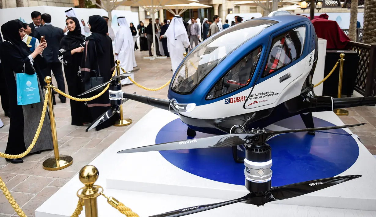 Pengunjung mengambil gambar drone atau pesawat tanpa awak EHang 184 yang dipamerkan di World Government Summit 2017, Dubai, Senin (13/2). EHang 184 ini mampu terbang hingga jarak 50 kilometer dengan kecepatan maksimum 160 km per jam. (STRINGER/AFP)