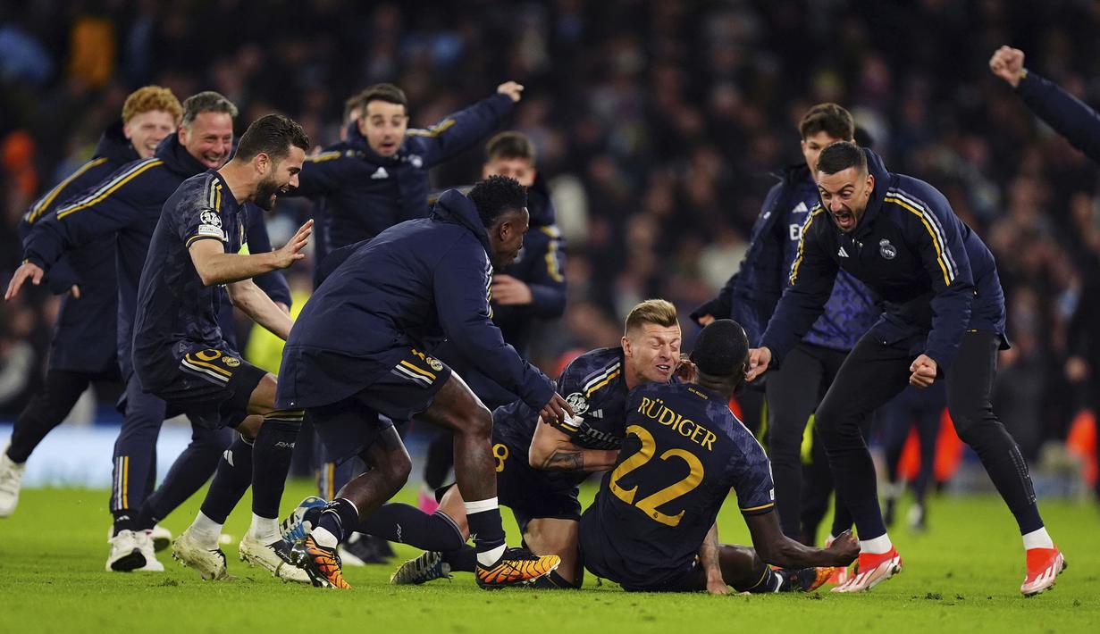 Para pemain Real Madrid merayakan gol penentu yang dicetak Antonio Rudiger ke gawang Manchester City saat adu tendangan penalti pada laga leg kedua perempatfinal Liga Champions 2023/2024 di Etihad Stadium, Manchester, Rabu (18/4/2024). Real Madrid menang 4-3 dalam adu penalti dan lolos ke semifinal. (PA via AP Photo/Mike Egerton)