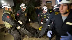 Petugas penyelamat membawa jenazah seorang turis setelah bus mengalami kecelakaan di Lima, Peru, (9/10). Pejabat Peru mengatakan sebuah bus wisata bersusun tidak terkendali dan berguling di jalan sempit di perbukitan. (AP Photo / Rodrigo Abd)