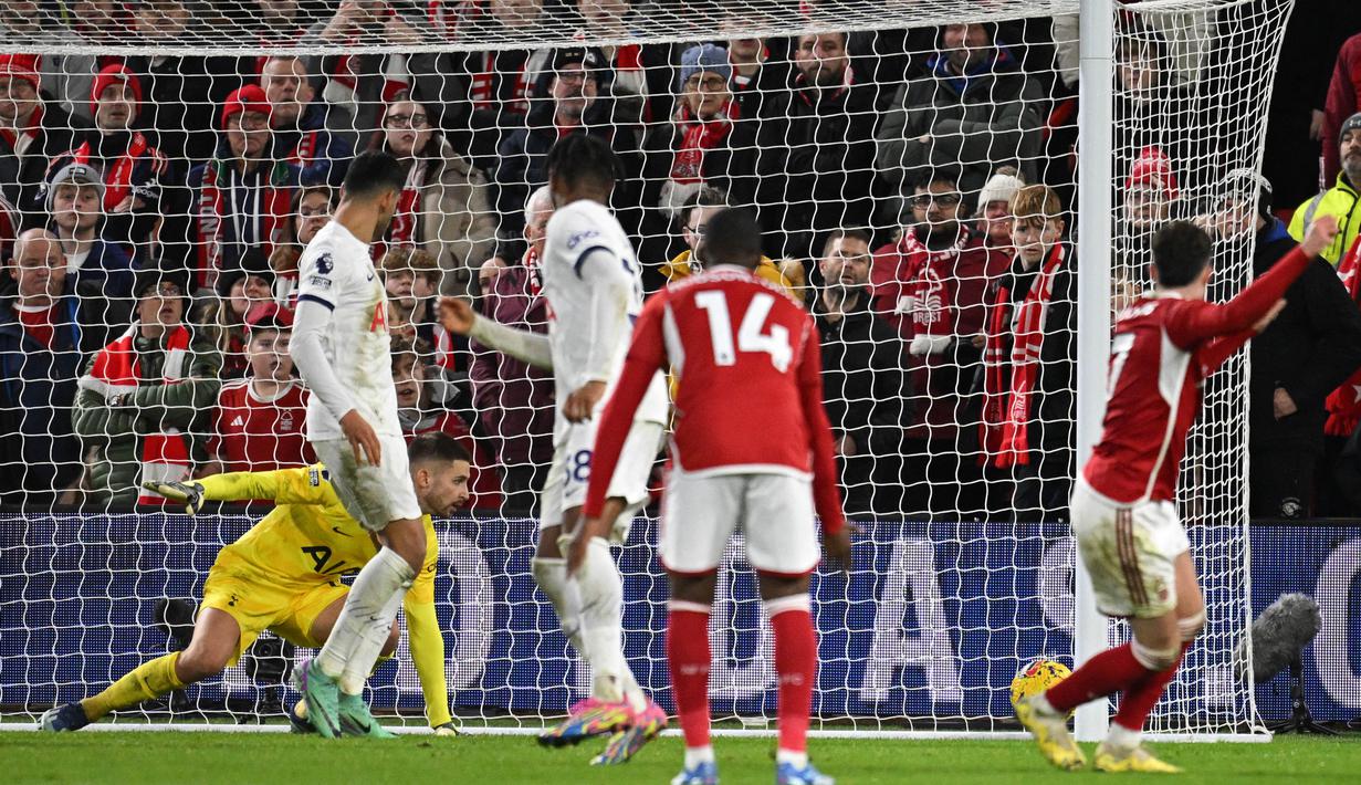 Pemain Nottingham Forest, Neco Williams (kanan), gagal menjebol gawang Tottenham Hotspur yang dijaga oleh Guglielmo Vicario dalam pertandingan pekan ke-17 Liga Inggris 2023/2024 yang berlangsung di The City Ground, Sabtu (16/12/2023) dini hari WIB. (AFP/Oli Scarff)
