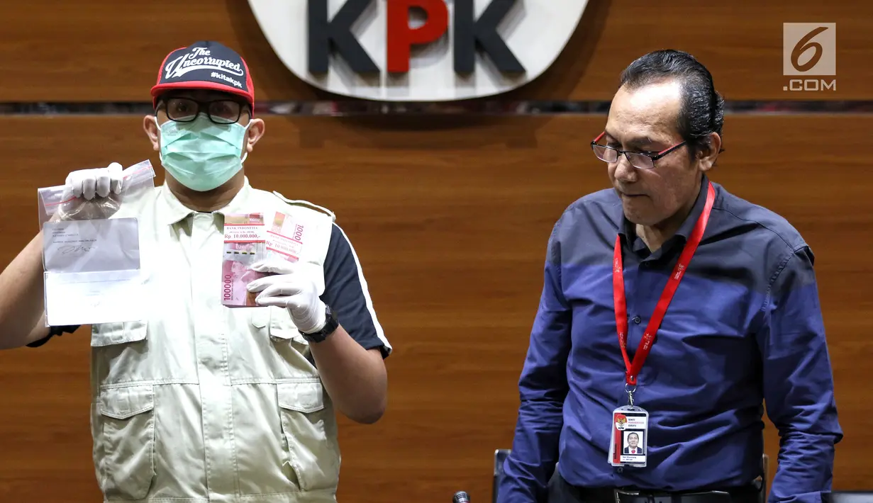Petugas dan Wakil Ketua KPK Saut Situmorang menunjukkan barang bukti OTT Direktur Teknologi PT Krakatau Steel, Wisnu Kuncoro terkait pengadaan barang dan jasa tahun 2019 di Gedung KPK, Jakarta, Sabtu (23/3). KPK menangkap 4 tersangka dengan barang bukti uang Rp 20 juta. (Liputan6.com/Johan Tallo)