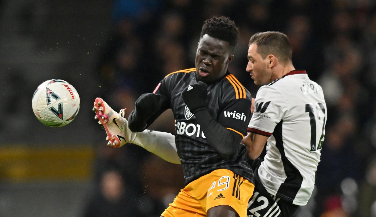 Bek Fulham Cedric Soares (kanan) bersaing dengan striker Leeds United Wilfried Gnonto (kiri) pada pertandingan putaran kelima Piala FA 2022/2023 di Craven Cottage di London, Rabu (28/2/2023) dini hari WIB. Gol Joao Palhinha pada menit ke-21 dan Manor Solomon pada menit ke-56 membuat Leeds United tidak berdaya di markas Fulham. (Photo by Glyn KIRK / AFP)