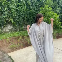 Rebecca Klopper yang biasanya senang tampil nyentrik dengan outfit-outfit berpotongan edgy, kini tampak mengenakan kaftan abu-abu dengan detail payet manik-manik di kerah dan sepanjang lengan. Foto: Instagram.
