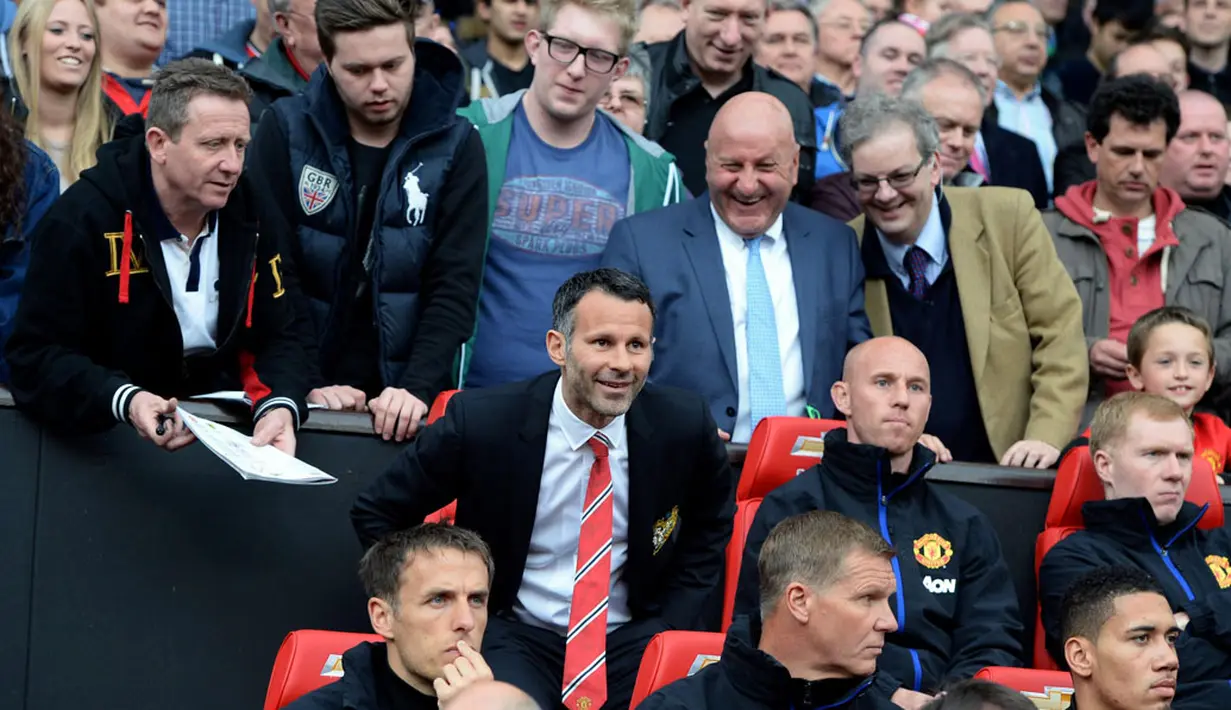 Ryan Giggs (berdasi) duduk di bangku bersama mantan pemain Manchester United lainnya yang kini menjadi staff pelatih tim yang bermarkas di Old Trafford, Inggris (27/4/2014). (REUTERS/Nigel Roddis)